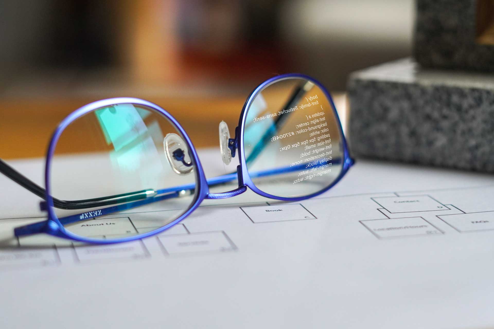 Image of reading glasses with CSS code reflected on lense