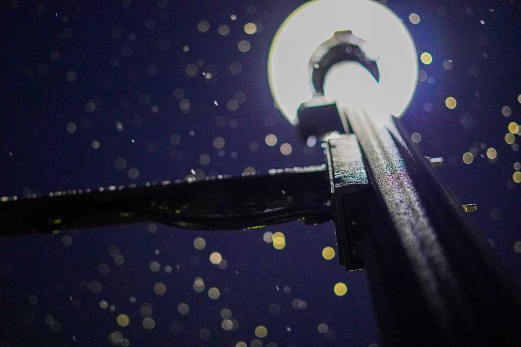 Image of a lamp post at night with snow falling